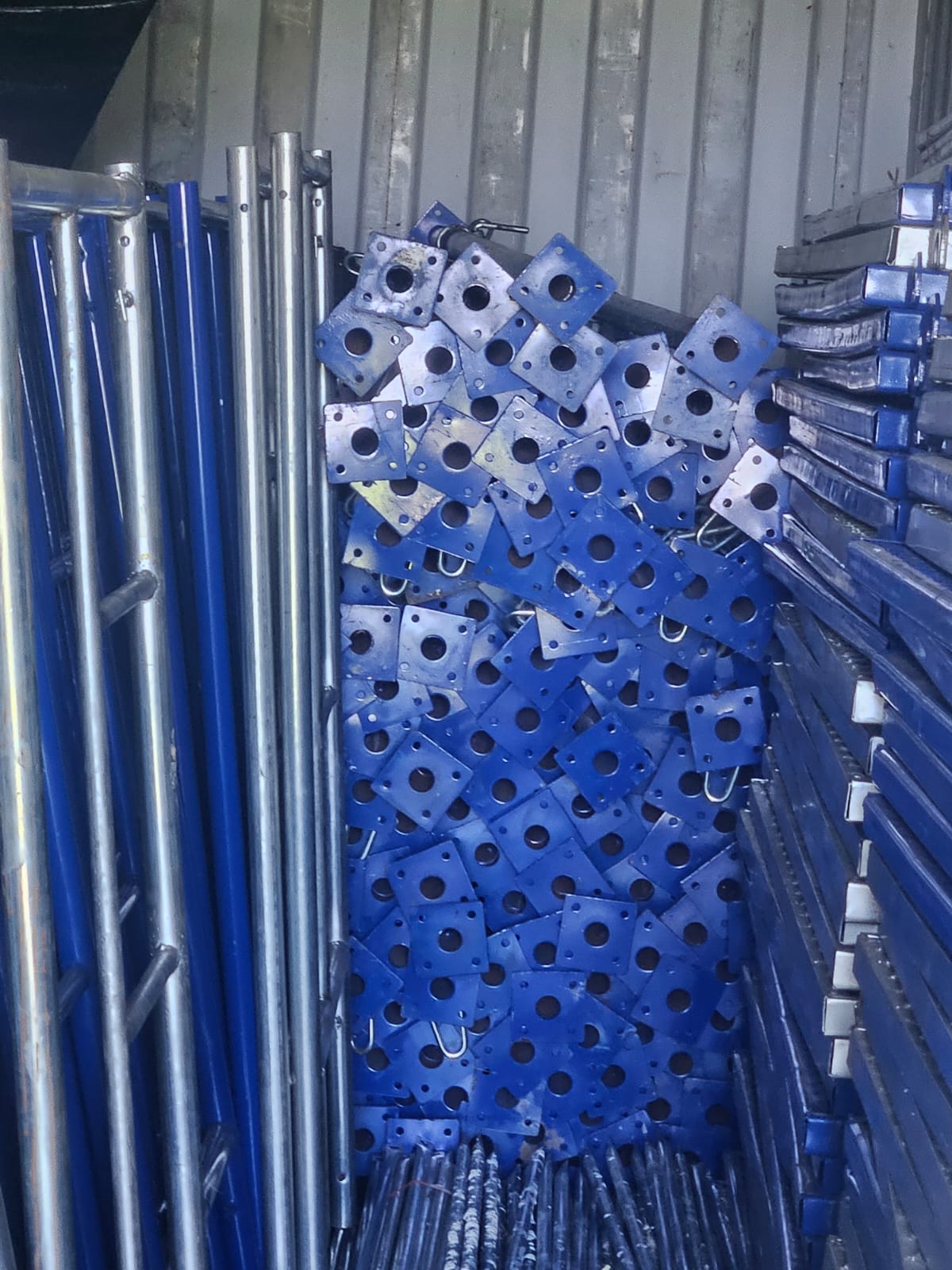 Close view of blue adjustable metal props, base plates, and support components